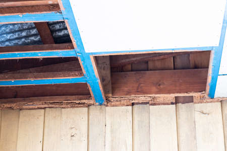 Close-up, dismantling, repairing the old ceiling panels and wooden frames of a house in preparation...