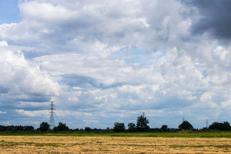 Scenery of rice fields that have been harvested, leaving only stubble, rice straw, near high-voltage...