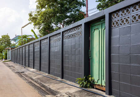 Side view Black painted brick wall stretches over the concrete as a protective fence for the residents.の写真素材