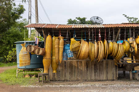 Woven wicker, made from a wide variety of bamboo, hangs under galvanized roofs for retail sales, often found on rural Thai roads.の写真素材