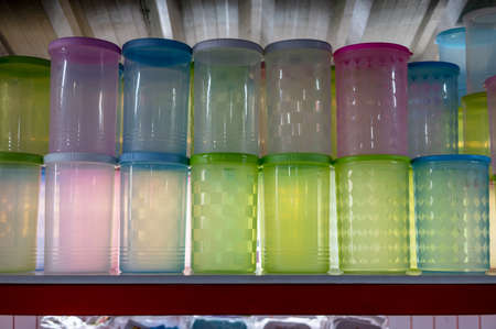 Close-up of a group of clear plastic jars with colorful lids stacked on top of each other for retail sale within a store, common in Thai rural markets.の写真素材