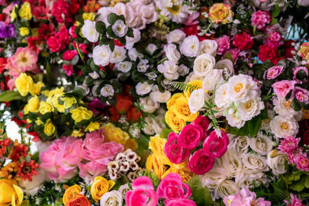 A variety of artificial fake flowers background, many bright colors, blooming, beautifully decorated, sold in one of the stores in the Thai rural market.の写真素材
