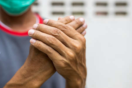 Close-up of two hands of a man squeezing in a massage due to nerve endings numbness in guillain...