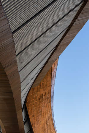 Low angle view, close-up, brown arched contemporary building exterior structure, abstract shape, distorted curves, a tourist attraction in a province of Thailand.の写真素材