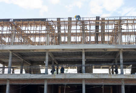 A view from below to the construction of a rowhouse building anchored by wooden scaffolding where...