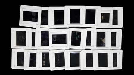 Background view from above, 35mm slide film lined on a sheet of printed glass, used as a dark background in a dark room to reminisce about old photographic memories.の写真素材
