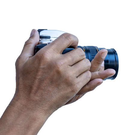Isolated close-up view on white background. Male Thai photographer fingers holding a DSLR film camera to aim at something with tensed arms.の写真素材