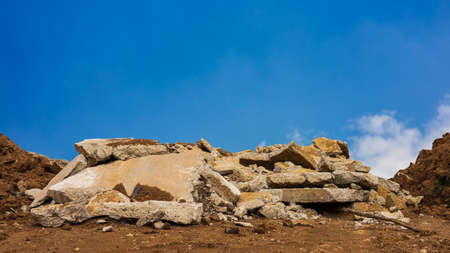 A view of the many old concrete blocks that have been demolished and demolished roads to be renovated and dumped on the ground to fill the river and canals with a blue sky in the background.の写真素材