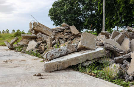 Close-up view of the rubble pile of concrete blocks demolished from the road surface and dumped near...