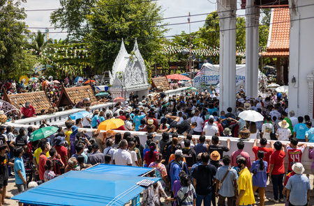Phichit, Thailand - September 18, 2022:Crowds of people are standing around the church to watch and join in the afternoon ordination ceremony in a rural Thai temple.のeditorial素材