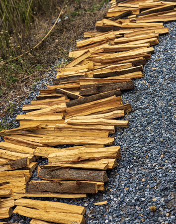 Pile of chopped firewood on a gravel path in the countryside