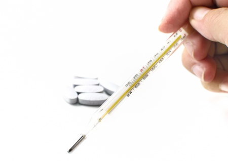 Thermometer and pills on white 