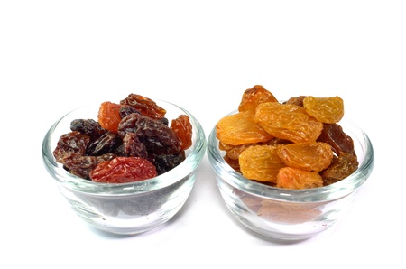 Raisins in glass bowl isolated on whiteの写真素材