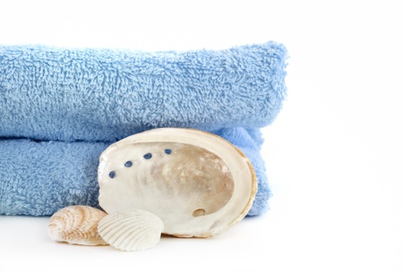 blue towel and sea shell isolated on whiteの写真素材