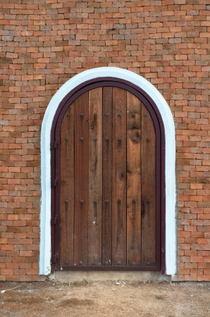 the arch wooden door with brick buildingの写真素材