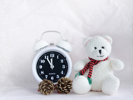 Alarm clock and teddy bear with pinecones for backgroundの写真素材