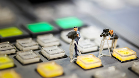 Miniature people : cameraman ,Videographer at work shooting on switcher control of Television Broadcast,color buttonsの写真素材