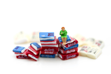 Miniature people :  reading books using as background education or business concept