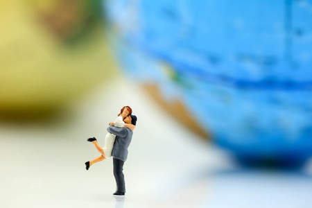 Miniature  people : love couple stand with globe world map balloon background,travel and lovely concept.の写真素材