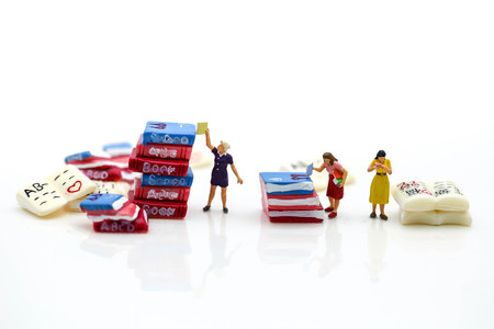 Miniature people :  reading books using as background education or business concept