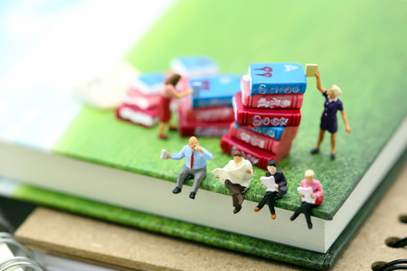 Miniature people : sitting on book using as background education or business concept.の写真素材