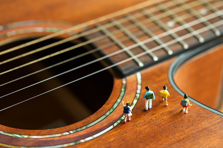 Miniature people : children and student  with acoustic guitar,time of relax or music relax,stationary,education concept.の写真素材