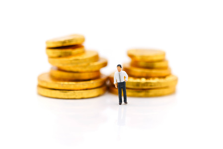 Miniature people : Businessman standing with  stack of coin, Money and financial concepts.の写真素材