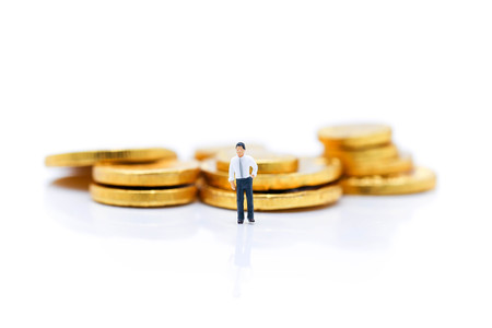 Miniature people : Businessman standing with  stack of coin, Money and financial concepts.