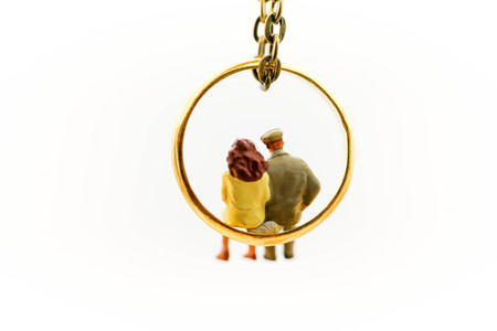 Miniature people : Couple of love sitting on  the ring,Love and Valentine's day concept.の写真素材