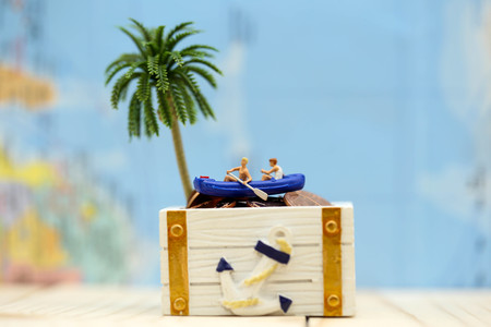 Miniature people : Travelers with paddle boat treasure coffer of gold.の写真素材