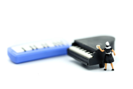 Miniature people : Maid cleaning a piano.