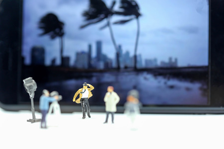 Miniature people : journalists , cameraman ,Videographer at work shooting with Weather Report.の写真素材