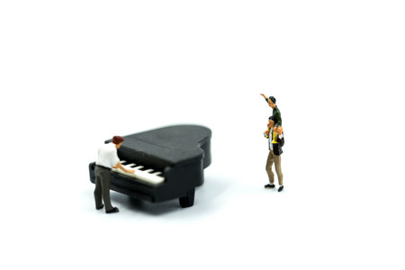 Miniature people : Man playing a piano with Father and son.の写真素材