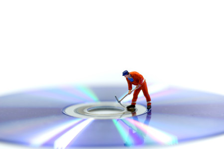 Miniature people : Worker digging a DVDs
