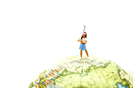 Miniature people : golfer stand with world map.の写真素材