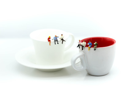 Miniatures people : sitting on a cup of coffee,relax and business concept.の写真素材