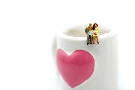 Miniature people : couple of love sitting on cup.の写真素材