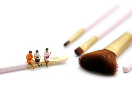 Miniature people: womans and friend sitting on cosmetic bottle using as background business, healthcare and beauty concept.の写真素材