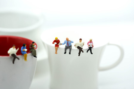 Miniatures people : sitting on a cup of coffee,relax and business concept.の写真素材
