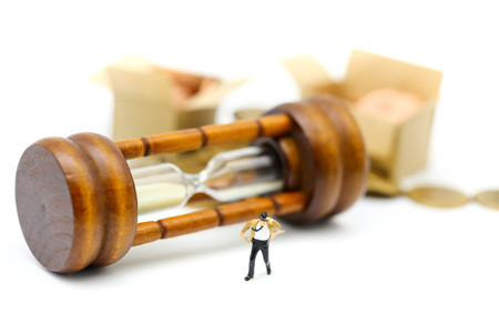 Miniature people :  businessman and Tie blowing in wind stand with Sandglass, hourglass.の写真素材