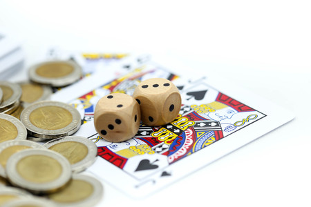 Rolls a wooden dices with coins and play card.