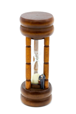Miniature people :  businessman look a watch  stand with Sandglass, hourglass.の写真素材