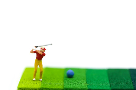 Miniature people : Golfer  playing on green background.の写真素材