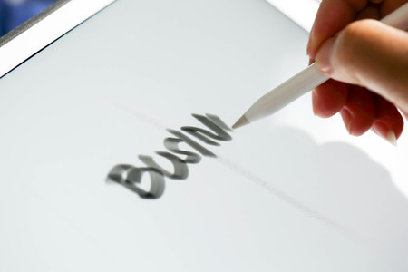 Businessman writing touch pad on wording Business.