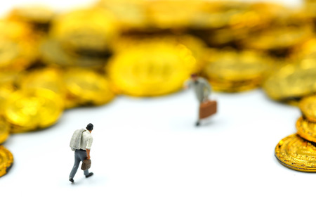 Miniature people : Businessman stand with gold coins.の写真素材