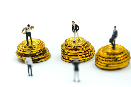 Miniature people : Businessman stand with gold coins.の写真素材