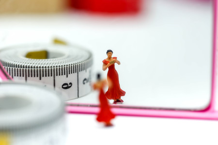 Miniature people : slim beautiful  woman with mirror and tape Measure,Healthcare and diet concept.の写真素材