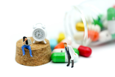 Miniature people : doctor stand with  drug and clock background,Health concept.の写真素材