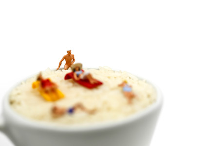 Miniature people : wearing swimsuit relaxing on white rice (Thai Jasmine rice).の写真素材