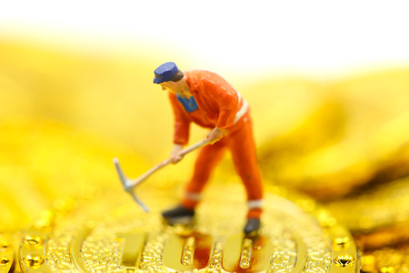 Miniature people : worker digging on gold coins.の写真素材